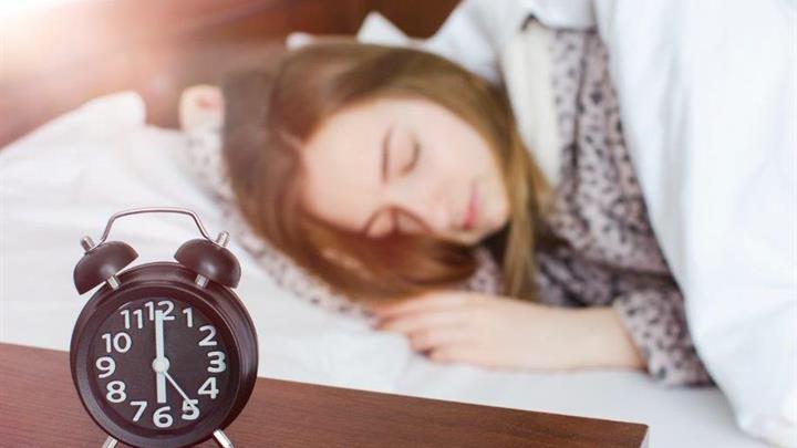Sleeping girl and alarm clock