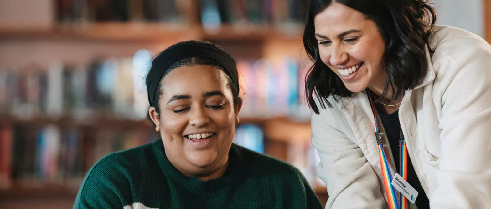 two women smiling and looking at something