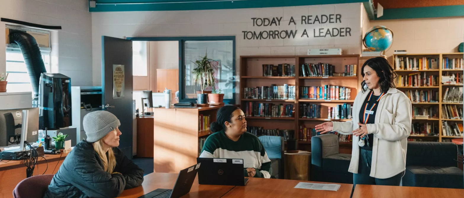 Three people talking in a BCMHSUS library