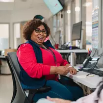 Woman sitting in office chair chatting with someone. 