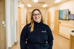 BCMHSUS staff member wearing blue jacket and smiling