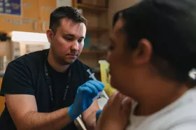 staff member administering shot to a patient