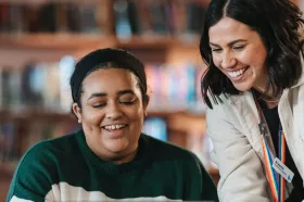 two women smiling and looking at something
