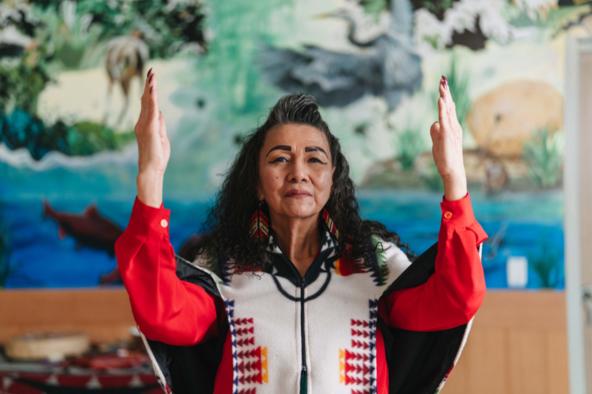 Indigenous woman with hands raised