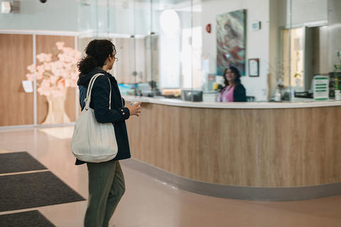 woman walking into the front desk area at Red Fish