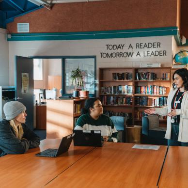 Three people talking in a BCMHSUS library