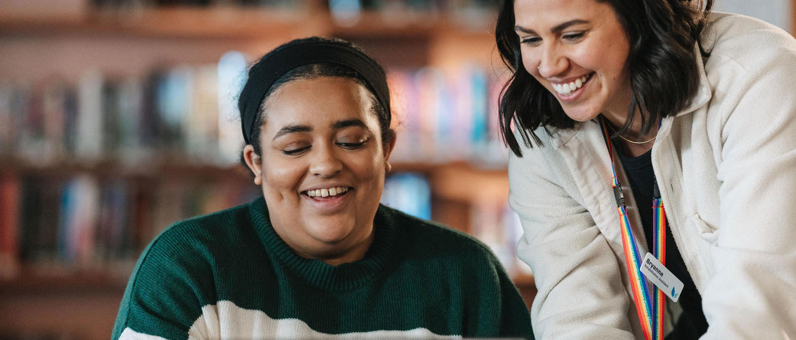 two women smiling and looking at something